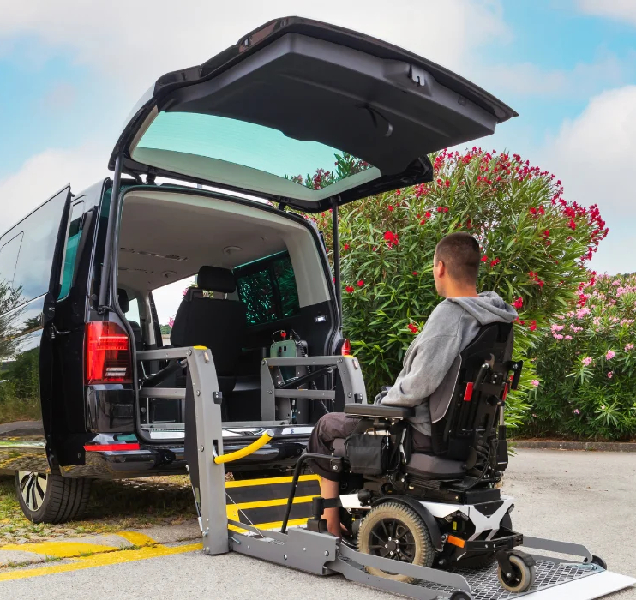 Image of a support worker assisting a client into a specialized transport vehicle
